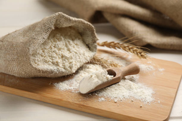 Sack and scoop of flour with wheat ears on wooden board, closeup Sack and scoop of flour with wheat ears on wooden board, closeup wholegrain flour stock pictures, royalty-free photos & images