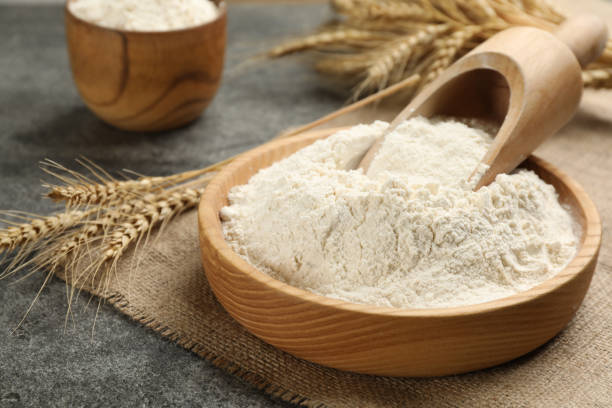 istock Plate with wheat flour and wooden scoop on grey table 1326410410