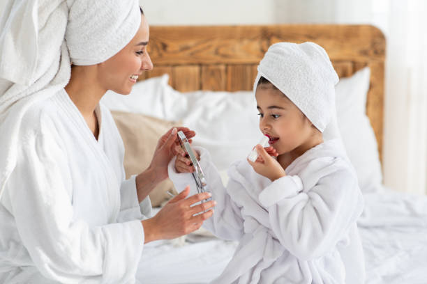 istock Adorable girl looking at mirror, applying lipstick 1326410421