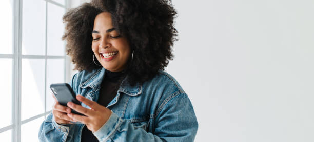 istock Smiling woman using her mobile phone 1326410458