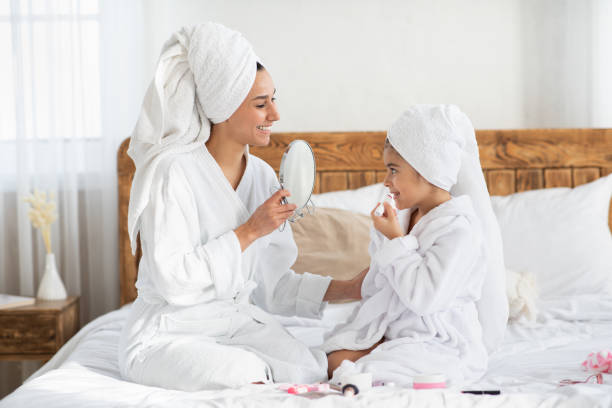istock Cute little girl putting lipstick on her lips 1326411191