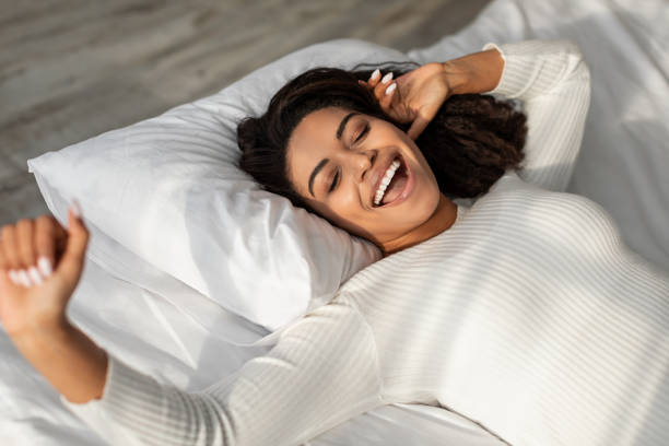 istock Happy African American lady stretching after waking up 1326411332