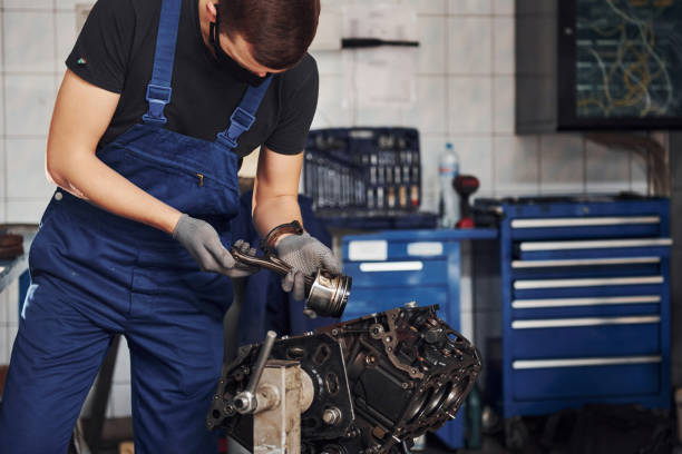 istock Professional repairman in black protective mask works with broken automobile engine 1326411742
