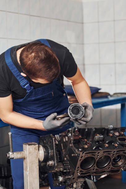 istock Professional repairman in black protective mask works with broken automobile engine 1326411791