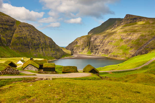 Picturesque green landscape with black houses in Faroe islands. Saksun Picturesque green landscape with wooden houses in Faroe islands. Saksun sod roof stock pictures, royalty-free photos & images
