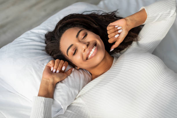 Happy African American female stretching after waking up