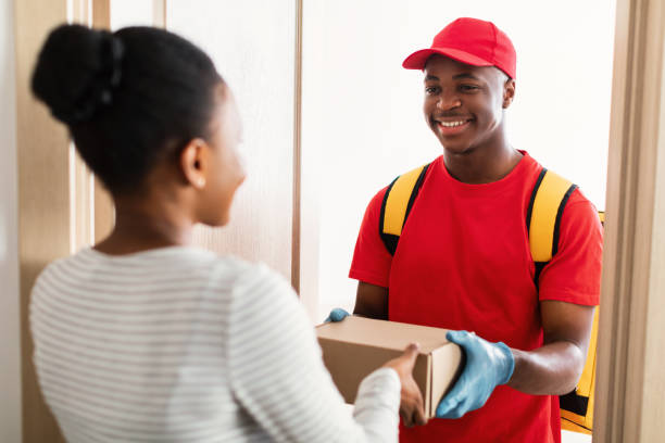 istock Courier Man Giving Box To Lady At Doors Of Home 1326413193