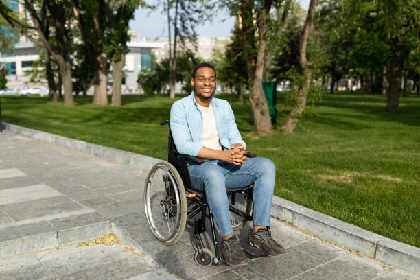 istock Accessible environment for disabled people concept. Happy black guy in wheelchair going down ramp on city street 1326414072
