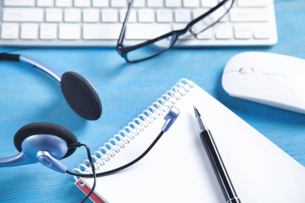 istock Customer service headset, computer keyboard and business objects on the blue background. 1326415368