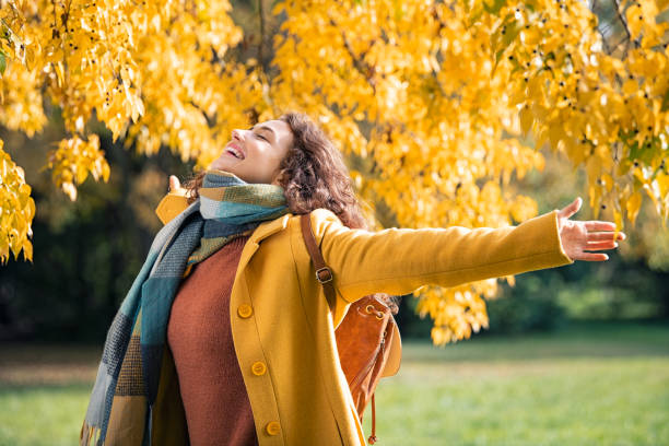 mujer despreocupada sintiéndose libre en hermosos colores otoñales - autumn women leaf scarf fotografías e imágenes de stock