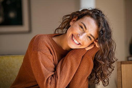 istock Mujer joven riendo mientras se relaja en casa 1326417862