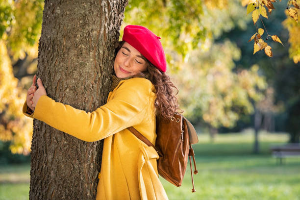 istock Young woman hugging tree in atumn at park 1326417936