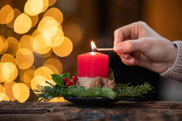 istock Woman lighting christmas advent candle 1326418037