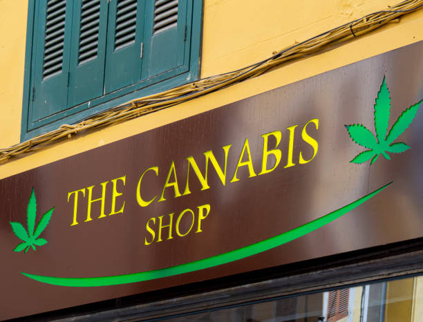 Cannabis shop logo and sign on Cannabis store in a city. Cannabis shop logo and sign on Cannabis store in a city. Marijuana legal dispensary. Selling hemp and CBD products for natural medicinal use - alternative medicine. front weed store cannabis store photos stock pictures, royalty-free photos & images