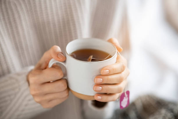 istock Woman holding hot tea cup 1326419419