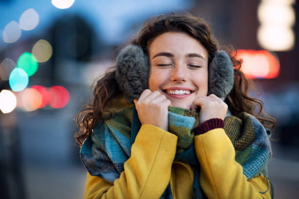 mujer disfrutar de ropa de abrigo en la noche de invierno - orejeras fotografías e imágenes de stock