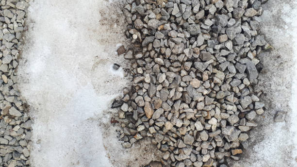 istock Gravel road texture covered with snow winter time. Pebble pattern, crushed stone concept 1326420683