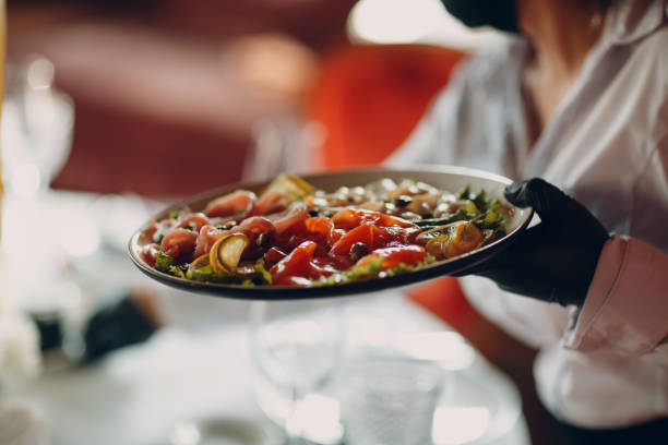 istock Various cold cuts on a plate waiter catering holds. 1326420700