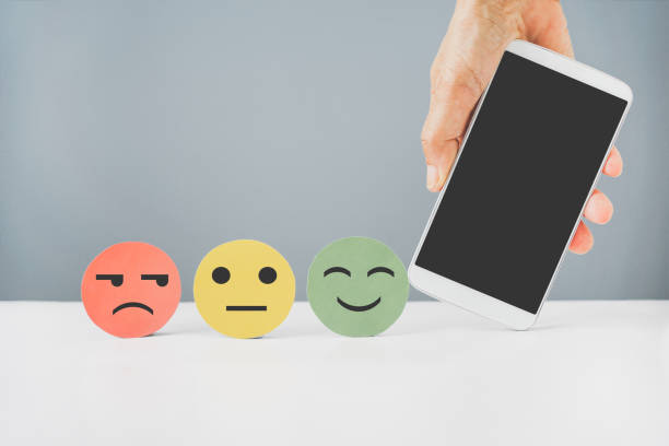 istock hand holding mobile phone with clipping path and emotion face for customer review, comment, experience, satisfaction survey, feed back concept 1326421995