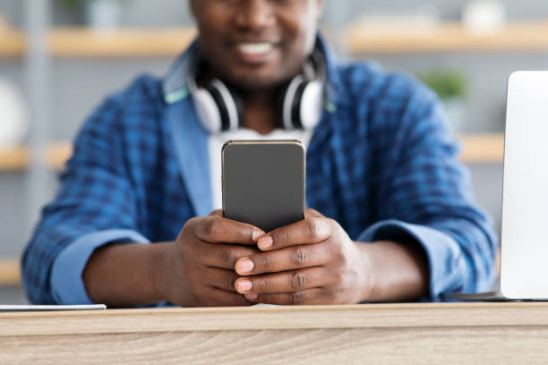 African american man using brand new smartphone, checking newest mobile application, selective focus