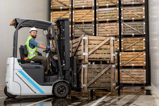 istock Employee on electric forklift carry container with ripe apples at storage 1326422438