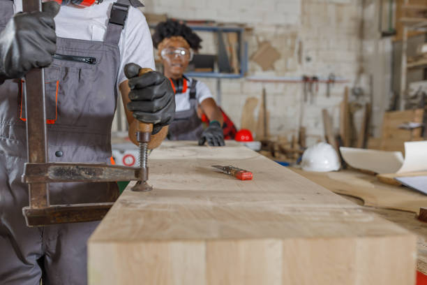 istock An Experienced Carpentry Worker and His Female African Coworker are Using a Clamp While Working in a Large Workshop. 1326423215