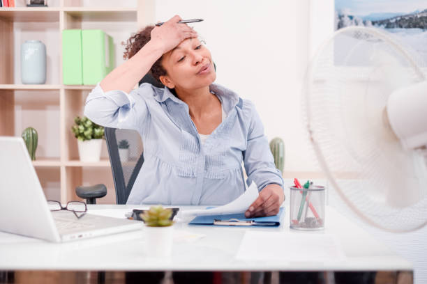 mulher trabalhando e sofrendo pelo clima quente de verão - office fan - fotografias e filmes do acervo