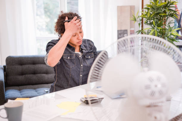 Woman working and suffering for summer hot weather Woman sweating and suffering for summer heatwave electric fan photos stock pictures, royalty-free photos & images