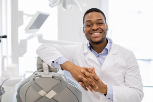 medico ortodonte nero professionale in posa sul posto di lavoro nella clinica moderna - dentist family doctor dental hygiene foto e immagini stock