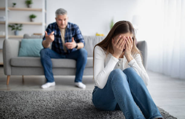 emotional abuse in marriages concept. mature woman crying on floor, her husband blaming or accusing her at home - arguing senior adult conflict couple imagens e fotografias de stock