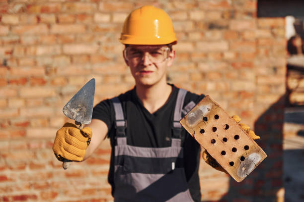 retrato de trabajador de la construcción en uniforme y equipo de seguridad que se para sobre la construcción y la celebración de ladrillos y herramientas - manual worker portrait helmet technology fotografías e imágenes de stock