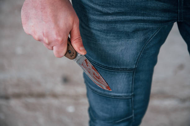 Close up view of killer that standing with knive with blood in hand Close up view of killer that standing with knive with blood in hand. knife crime photos stock pictures, royalty-free photos & images
