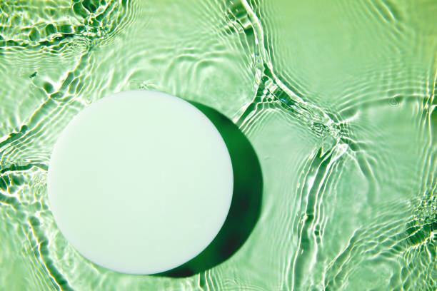 Empty white circle podium on transparent green clear water background