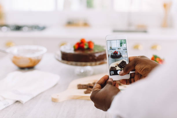 携帯電話でケーキの写真を撮る女性のクローズアップ - cake women confectioner photography ストックフォトと画像