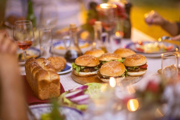 istock Burgers on wooden board on dining table during dinner party at backyard 1326435937