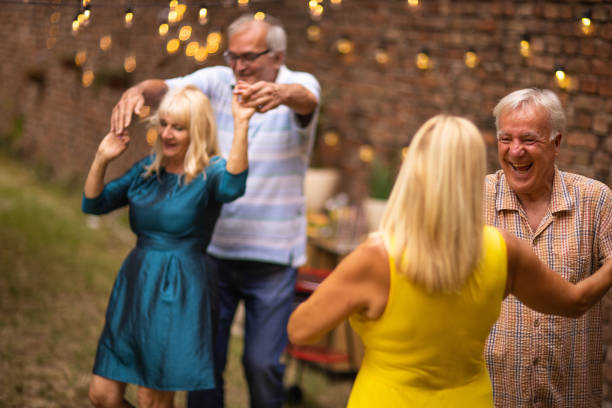 istock Senior people having fun and dancing on garden party 1326436286