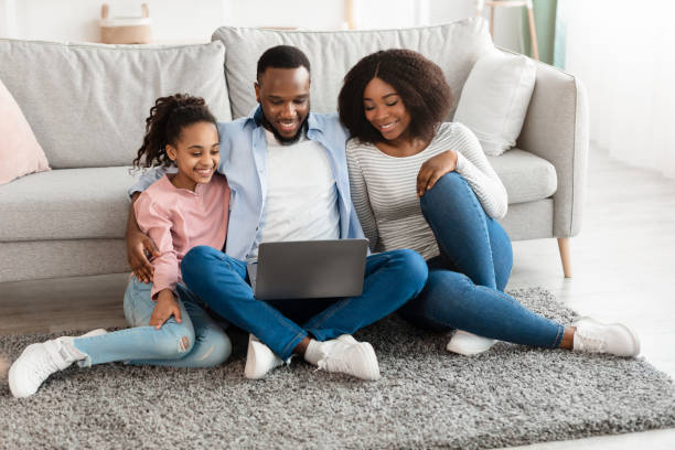istock Happy black family using laptop in living room 1326437310