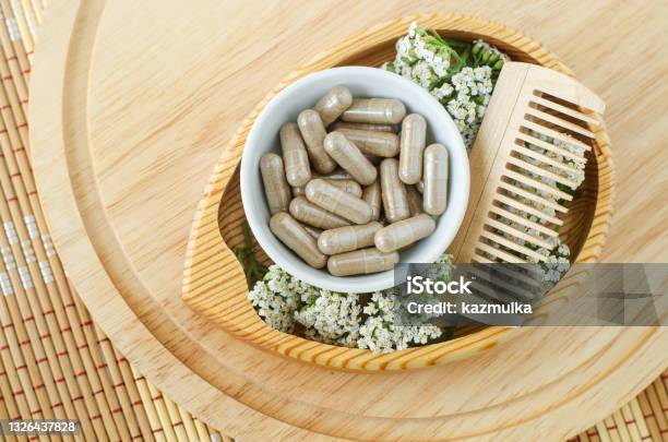 Small White Bowl With Food Supplement Capsules Wooden Hairbrush And Yarrow Flowers Natural Healthcare Herbal Medicine Haircare And Beauty Treatment Top View Copy Space Stock Photo - Download Image Now