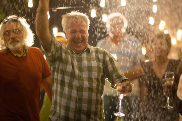 istock Happy senior friends having a best time in life on party at backyard while it's raining 1326437836