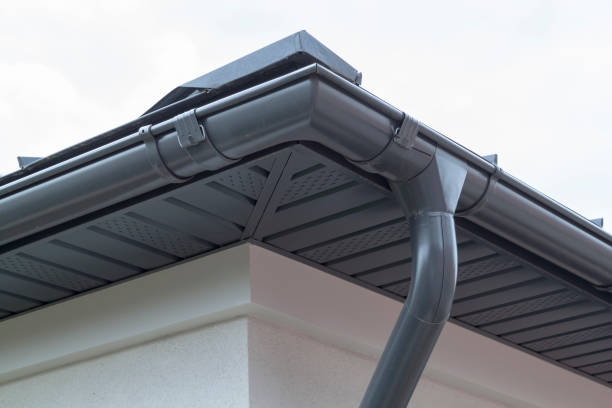 新しい灰色の金属タイルの屋根と雨の側溝と家のコーナー。金属側溝システム、溝および排水管の外装 - metal aluminum steel pipe ストックフォトと画像
