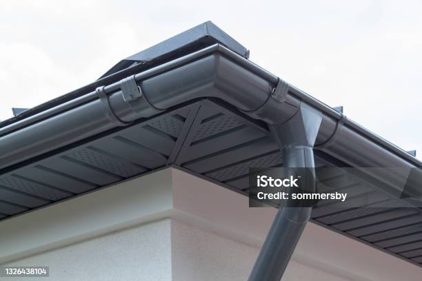Corner Of House With New Gray Metal Tile Roof And Rain Gutter Metallic Guttering System Guttering And Drainage Pipe Exterior Stock Photo - Download Image Now