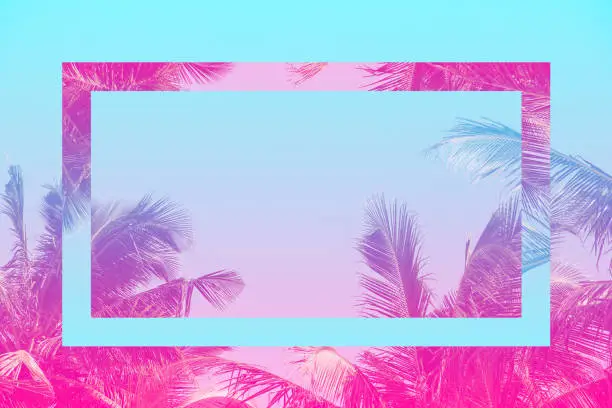 Photo of Colorful tropical 80s 90s style coconut palm tree with futuristic mirror effect in pink and blue toned