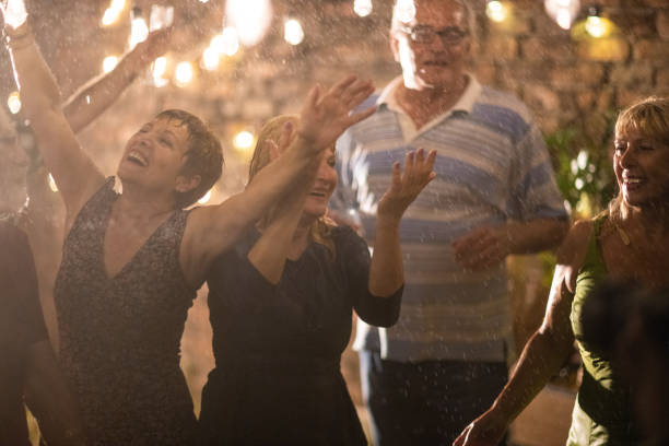 istock Group of senior people dancing on garden party while it's raining 1326439186