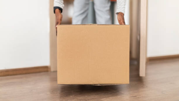 istock Unrecognizable African Lady Putting Cardboard Box On Floor Entering Home 1326441913