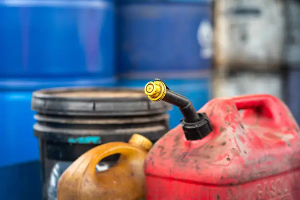 A gasoline or diesel fuel canister which is placed at factory chemical storage area. Industrial object photo. Close-up and selective focus at the containment tube sealing cap.