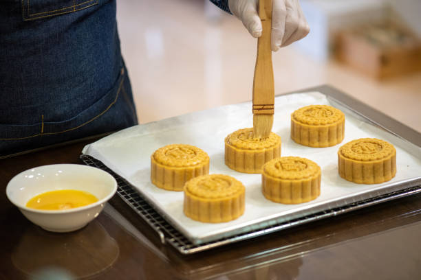 istock Baker painting with eggs dough to make Homemade Chinese mooncake on baking tray 1326443343