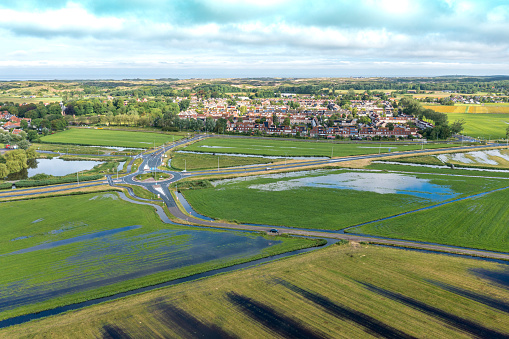Aerial footage of as typical suburban housing estates and wetlands in the foreground.