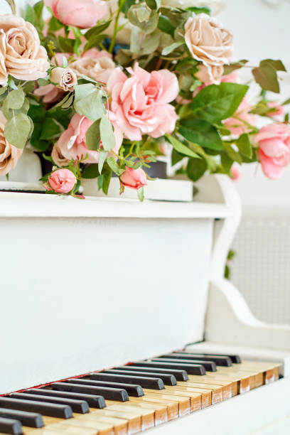 istock White grand piano with rose flowers in white classic interior, copy space 1326443611