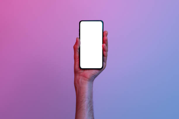 istock Phone with a white, blank screen in a woman's hand on a gradient background 1326444011