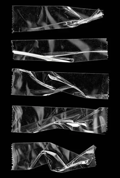 Photo of set of transparent tape or strips isolated on black background with nice light reflection.